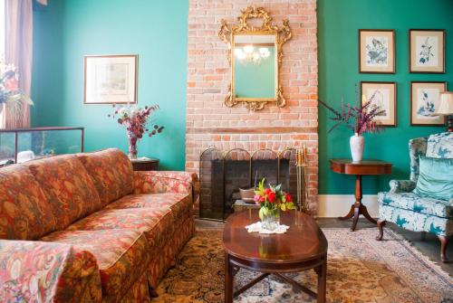 a living room with a couch and a fireplace at Grenoble House in New Orleans