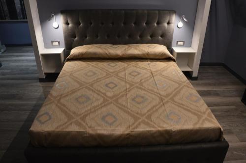 ein großes Bett in einem Zimmer mit 2 Tischen in der Unterkunft Luxury Bellevue Centro Città in Pescara