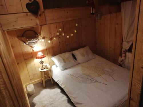 ein Schlafzimmer mit einem Bett in einer Holzwand in der Unterkunft Logicoeur in Gérardmer