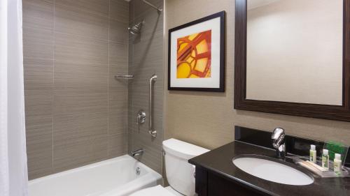 a bathroom with a sink and a toilet and a mirror at Holiday Inn Lower East Side by IHG in New York