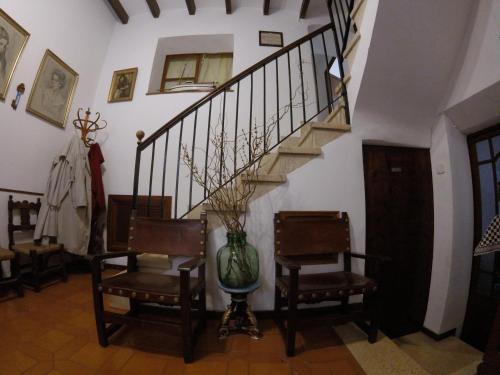 a hallway with a staircase with two chairs and a vase at Casa Margarita in Sóller