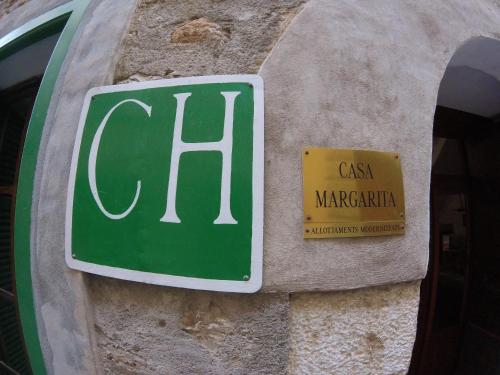 a green sign on the side of a stone wall at Casa Margarita in Sóller