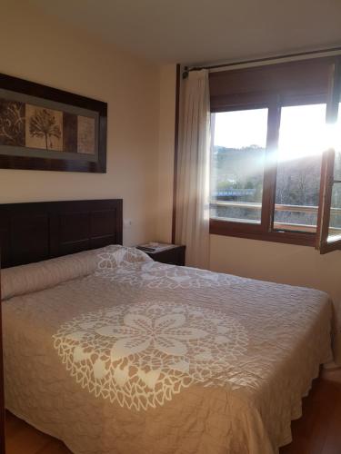 カンガス・デ・オニスにあるApartamento Jardines del Sellaのベッドルーム(大型ベッド1台、窓付)