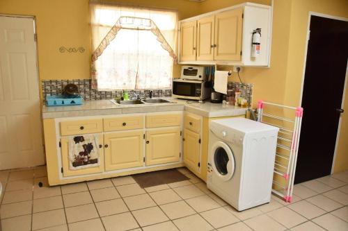 a kitchen with a washing machine and a washer at Aanola Villas A5 Hushed Hacienda in Charlotte