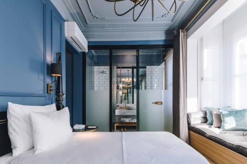 a bedroom with blue walls and a bed and a couch at The Soul Istanbul Hotel in Istanbul