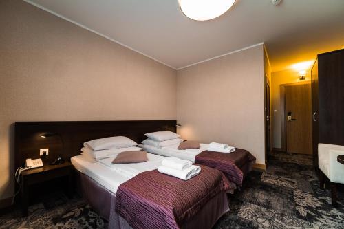 a hotel room with two beds and a sink at Hotel Coloseum in Jarosław