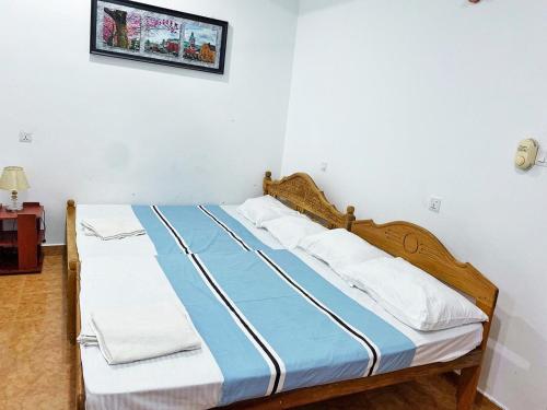 a bed with blue and white sheets in a room at Hotel Juli Reception in Mannar