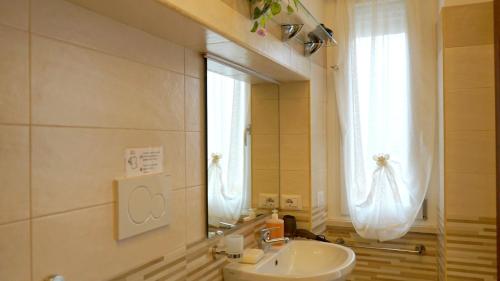 a bathroom with a sink and a mirror and a window at La Lanterna Sul Comò in Civitavecchia