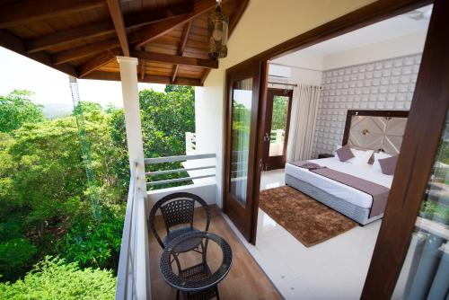 a master bedroom with a bed and a balcony at Mount Rich Rumassala By JMS Group in Unawatuna