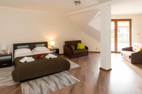Un dormitorio con una cama, un sofá y una silla. en Dom Grinholc, en Rumia