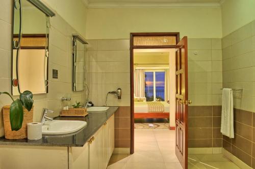 un bagno con 2 lavandini e una vasca di Sovereign Hotel a Kisumu