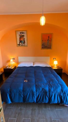 uma grande cama azul num quarto com duas lâmpadas em Alloggio turistico em Capodimonte