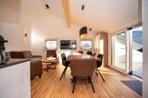 een eetkamer en een woonkamer met een tafel en stoelen bij Appartementhaus AURUM in Zell am See
