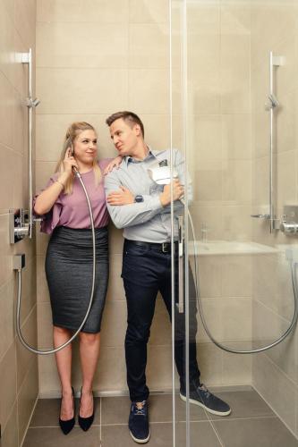 a man and a woman standing in a shower at Kaiser Apartments - Wohnpark Graz-Gösting in Graz