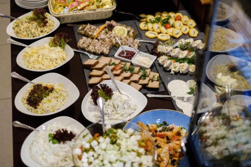 a table filled with plates of food on a table at Hotel Coloseum in Jarosław