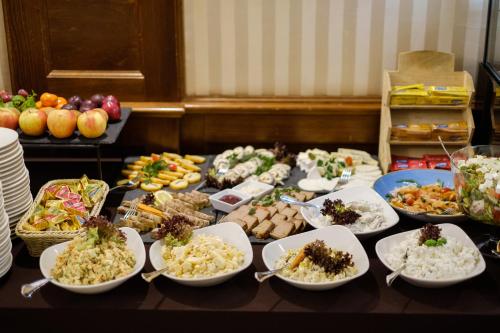 a table with many dishes of food on it at Hotel Coloseum in Jarosław