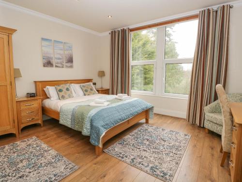 Un dormitorio con una cama y una ventana grande. en Eden Lodge, en Bardsea
