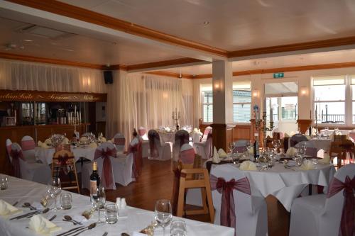 a room filled with tables with white tablecloths at The Pegwell Bay Hotel in Ramsgate