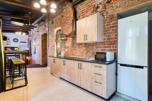 a kitchen with a refrigerator and a brick wall at Winterfell on Novokuznetskaya in Moscow