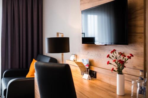 a living room with a couch and a television at Hotel Coloseum in Jarosław