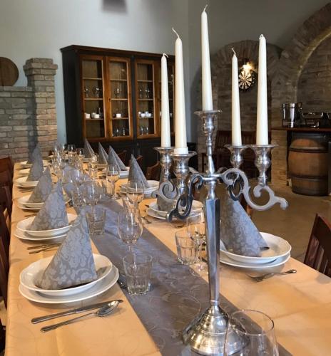 a long table with plates and candles on it at Vass-Villa Vendégház in Szekszárd