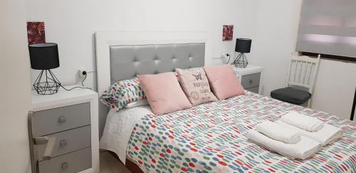 een slaapkamer met een groot bed met roze kussens bij Casa plaza Melegís in Melegis