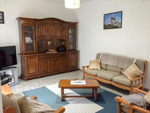 - un salon avec un canapé et une télévision dans l'établissement Pagu Pagu de Paradisu - A little bit of paradise, à Gàiro SantʼElena