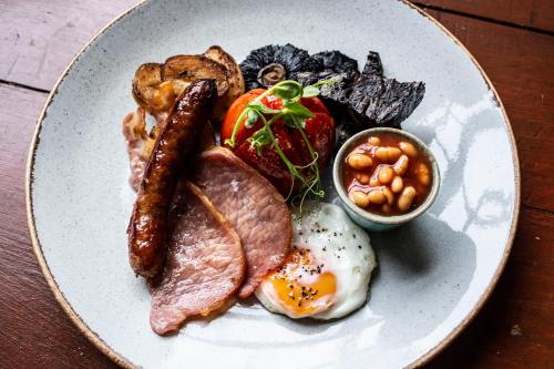 un plato de desayuno con huevos salchichas tocino y frijoles en The Royal Hotel, en Kirkby Lonsdale