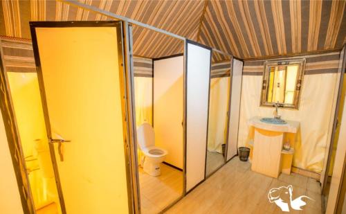 a small bathroom with a toilet and a sink at Sahara Desert Camp in Merzouga