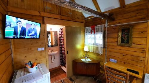 a room with a tv on the wall of a cabin at Etno selo EDEN in Žeravački Potok