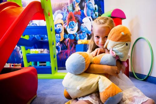 a little girl is holding a stuffed animal at Hotel Nowy Dwór Elizy blisko Sky Bridge in Długopole-Zdrój
