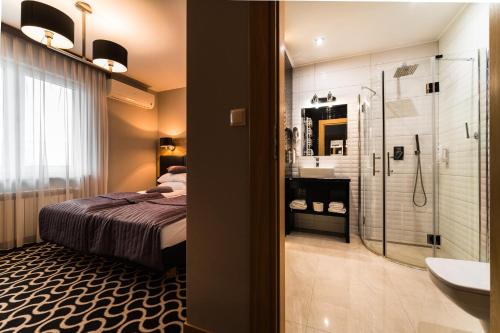 a bathroom with a bed and a shower and a sink at Hotel Coloseum in Jarosław