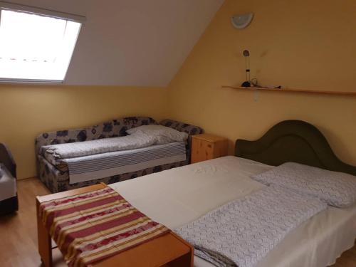a bedroom with two beds and a window at Gabi Szálló I. in Poroszló