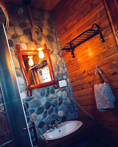 a bathroom with a sink and a stone wall at Vila Mali Tornik in Zlatibor