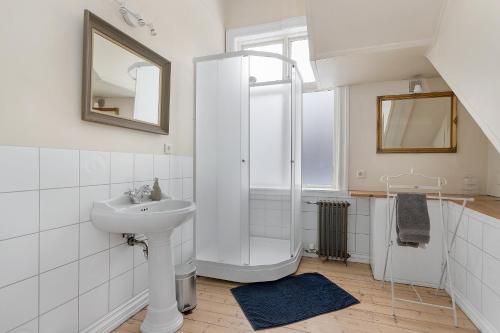 a white bathroom with a sink and a shower at Sudurgata - Authentic Reykjavik Style Apartment in Reykjavík