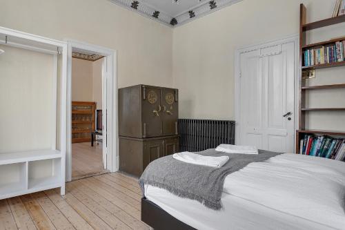ein Schlafzimmer mit einem großen Bett und einem Kühlschrank in der Unterkunft Sudurgata - Authentic Reykjavik Style Apartment in Reykjavík
