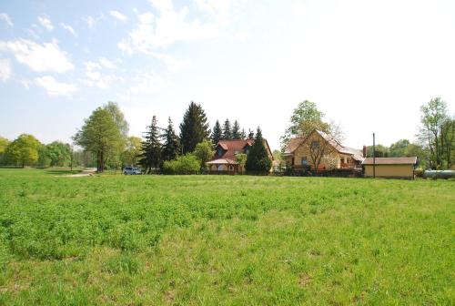 um campo de relva verde com uma casa ao fundo em Ferienwohnung Lehmann, Ursel em Burg Kauper