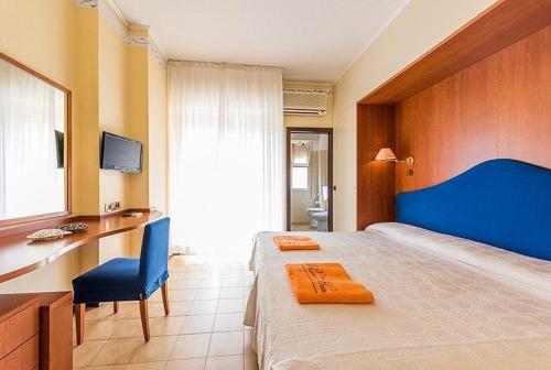une chambre avec un grand lit et une tête de lit bleue dans l'établissement Hotel Palladio B&B, à Cervia