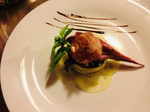 a white plate with a dish of food on it at Zur Mühle Wohlfühloase in Trodena