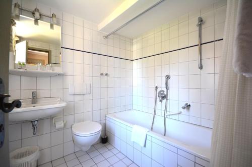 a bathroom with a tub and a toilet and a sink at Landhotel Schloss Buttenheim in Buttenheim