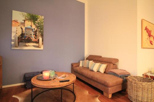 ein Wohnzimmer mit einem Sofa und einem Tisch in der Unterkunft Villa Hintze Wohnung 9 in Heringsdorf