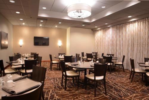 a dining room with tables and chairs and a tv at Holiday Inn Gaithersburg, an IHG Hotel in Gaithersburg