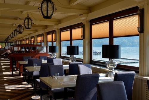 a restaurant with tables and chairs and a view of the ocean at Tourist Resort Ribarsko Ostrvo in Novi Sad