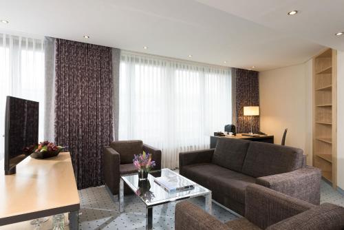 a living room with a couch and a table at Maritim Hotel Düsseldorf in Düsseldorf