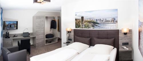 a living room with a white couch and a desk at Parkhotel Ahrbergen in Giesen