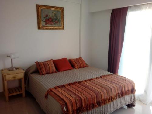 um quarto com uma cama e uma fotografia na parede em Departamento nuevo y luminoso en el centro. em La Rioja