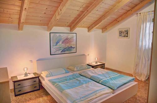 - une chambre avec un grand lit et 2 tables de chevet dans l'établissement Ferienwohnung Petra, à Bischofsmais