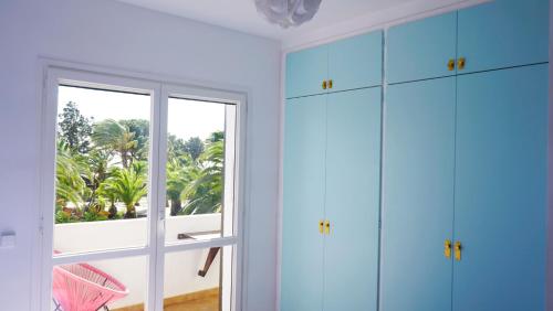 Habitación con armarios azules y ventana. en Villa Paradise by MarCalma en Montroig