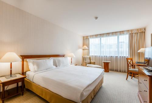 a hotel room with a large bed and a window at Evergreen Laurel Hotel in Levallois-Perret