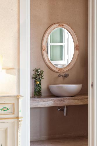 a bathroom with a white sink and a mirror at Casanova di Neri Relais in Montalcino